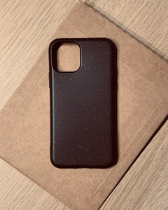 Compostable & Co. iPhone 11 black biodegradable phone case with recycled paper background